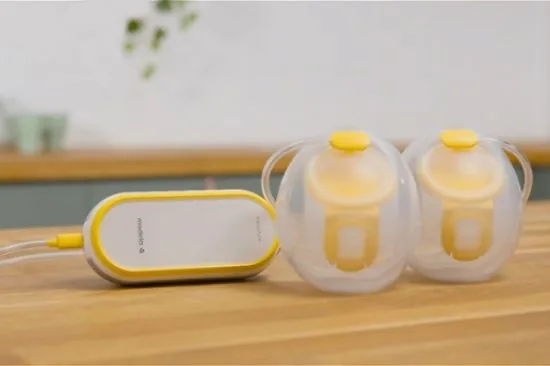 Medela Freestyle Hands-free motor and collection cups connected by tubing on a counter
