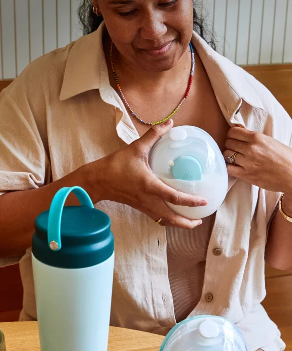 Person holding a Willow Go pump at the front of a bra.